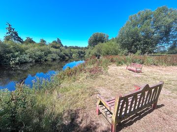 Open public seating area with river views, accessed on approach to village.