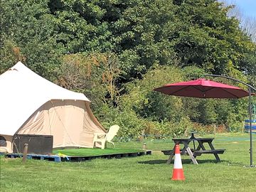 Shaded picnic bench by each bell tent