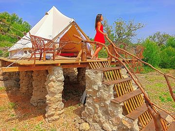 Bell tent raised on pillars