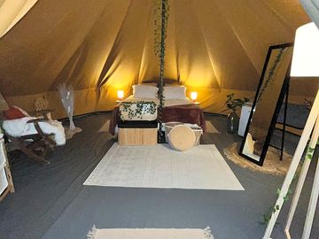 Furnished bell tent with double bed, seating, storage and lighting