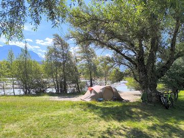 Pitch between the river and trees
