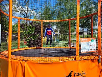 Aire de jeux avec toboggan, balançoire, terrain de home-ball et trampoline.