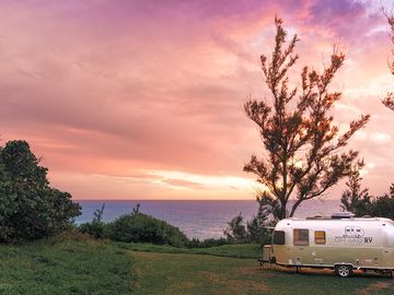 The rv, surrounded by lush greenery and sea views