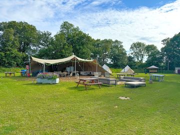 Stretch tent with large communal fire pit and outdoor seating