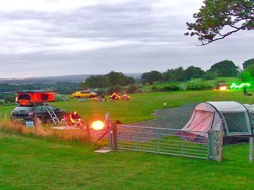 Campfires at dusk. tents and campervans