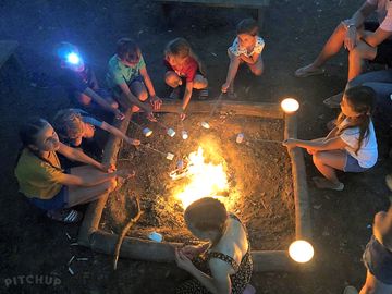 Children toasting marshmallows at the communal campfire