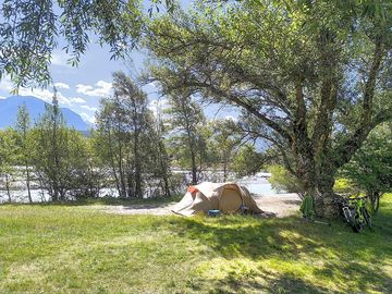 Pitch between the river and trees