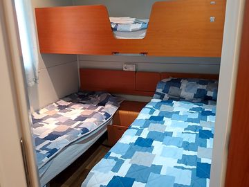 Camera con tre letti singoli, di cui un letto è a castello.