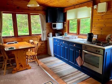 Kitchen/dining area with electric cooker, hob, kettle, fridge, and microwave