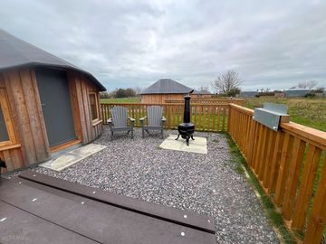 Fire pit and seating area outside the wooden yurt