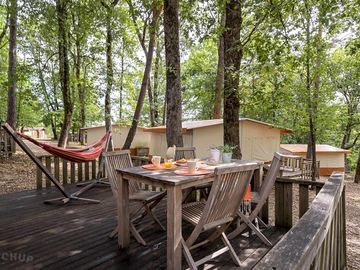 Decking with seating and a hammock outside of the safari tent