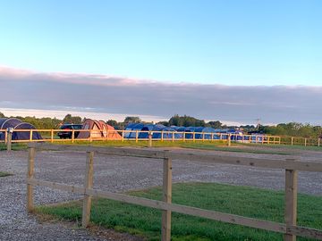 Outside the toilet block. Hard standing pitches on the right & tent pitches the other side of fence