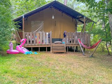 Safari tent shaded by trees