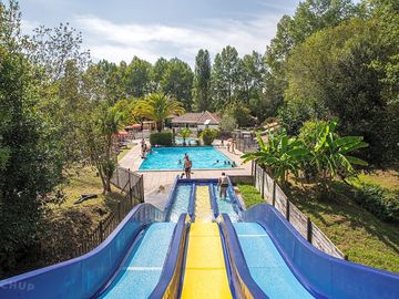 espace aquatique avec piscine, pataugeoire et piste de toboggans