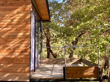 The cabin's balcony overlooking oak trees