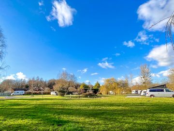 Meadow brook field showing non-electric grass pitches for tents as well as hardstanding pitches.