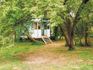 The gypsy caravan, in the old orchard under the damson and pear trees