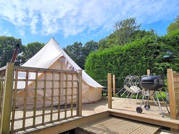 The bell tent has a deck with barbecue and seating