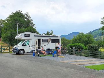 Motorhome parking area in the campsite with the stream behind.