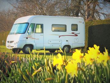 Motorhome on a hardstanding electric pitch in early spring