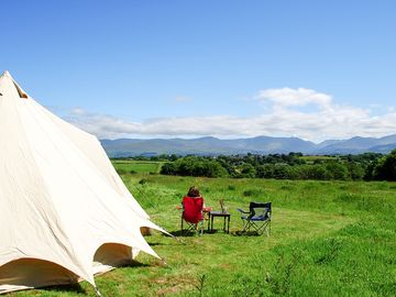 Each tent has a sitting area with camping chairs and a table