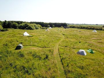 The camping meadow at the big sky hideaway in lincolnshire. grass pitches mowed into longer grass