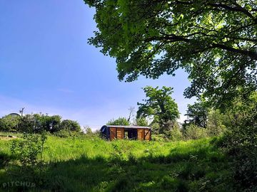 Our chillout firepit area with the old refurbished railway truck viewed from down by the stream.