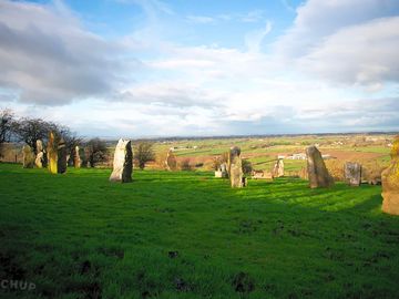 Stone circle with rural scenery behind
