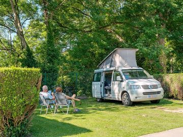 emplacements électrifié entre 80 et 100m² délimité par une haie pour caravane, camping-car et tentes