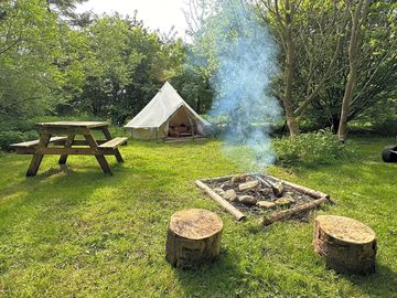 Tent pitch with firepit and picnic table