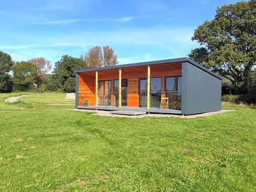 The cabin is surrounded by greenery
