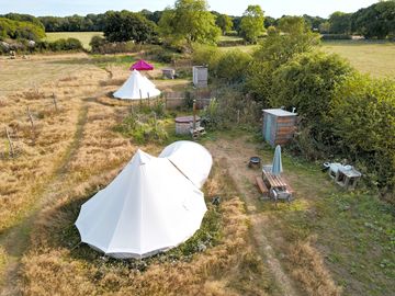 Western edge, and then fire pit bell tents. each have a fire bowl; hot tub; and toilet / shower.