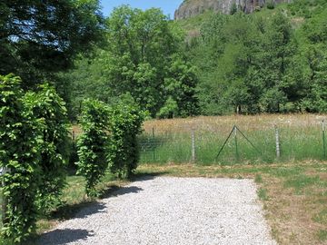 Levelled motorhome pitch, part gravel and part gras with views of the volcano