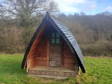 Basic wooden camping pod, bring everything except your tent.