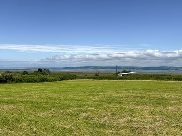 Non-electric grass pitches with estuary views