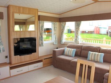 The living area, with L-shaped sofa and electric fire