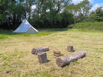 Bell tent and log seating area