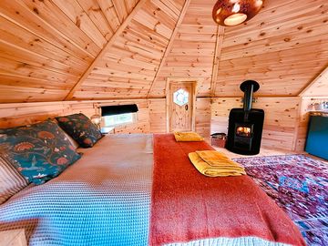 Cozy wood burning stove next to the bed