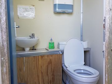 One of four flushing toilets, with soap, toilet roll and hand towels all provided