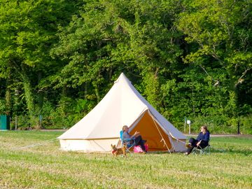 Guests sit outside of the bell tent