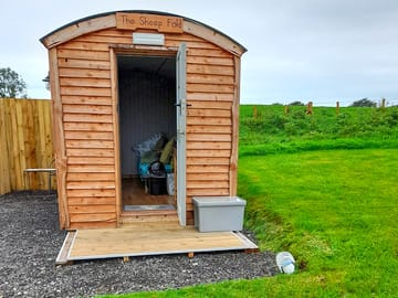 Outside of shepherd's hut with storage box on the decking