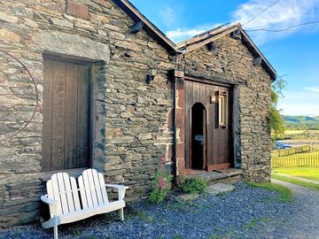 Entrance to Dog Crag Cabin with bench outside.