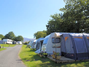 Grass touring pitches backed by trees