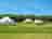 Rolling Fields Glamping: Long meadow grass and wildflowers separating the tents