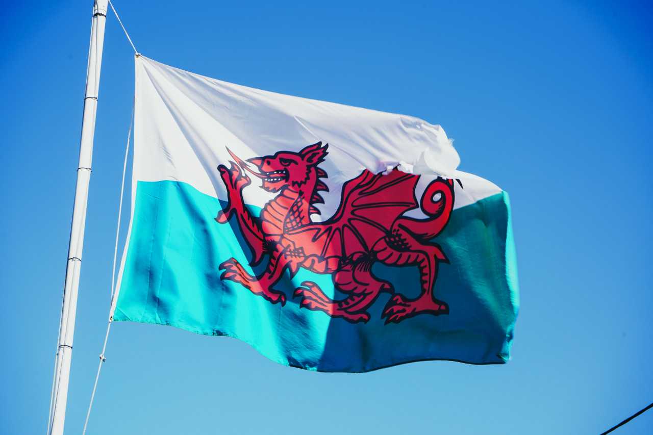 The Welsh flag flying over the streets of Wrexham (Catrin Ellis/Unsplash)