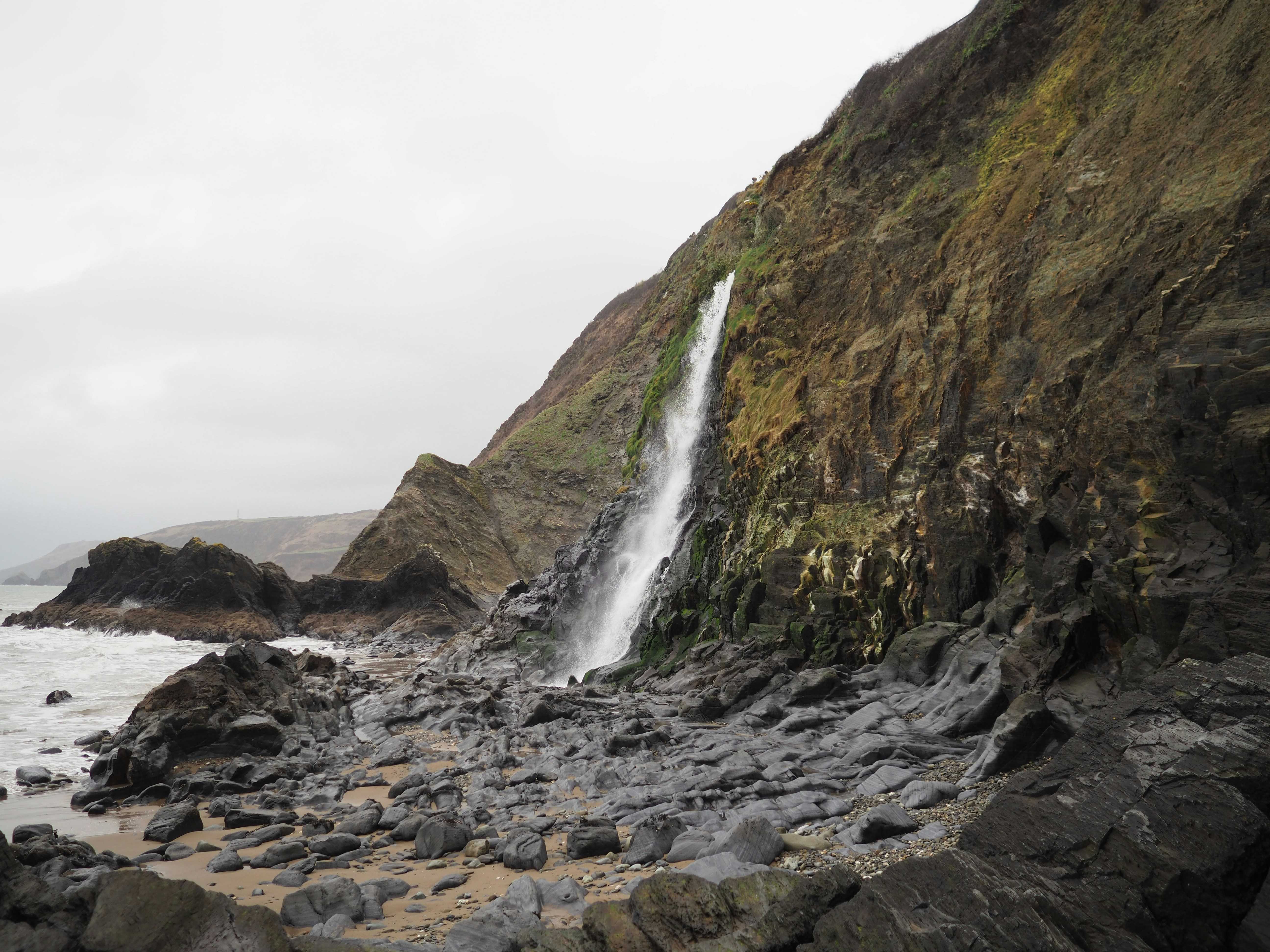 Visit at low tide to see Tresaith’s waterfall up close (Trev Morris/Unsplash)