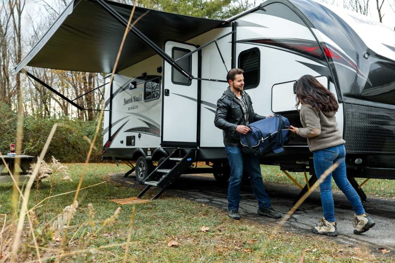 A couple moving their belongings into a caravan (Togo RV / Unsplash)