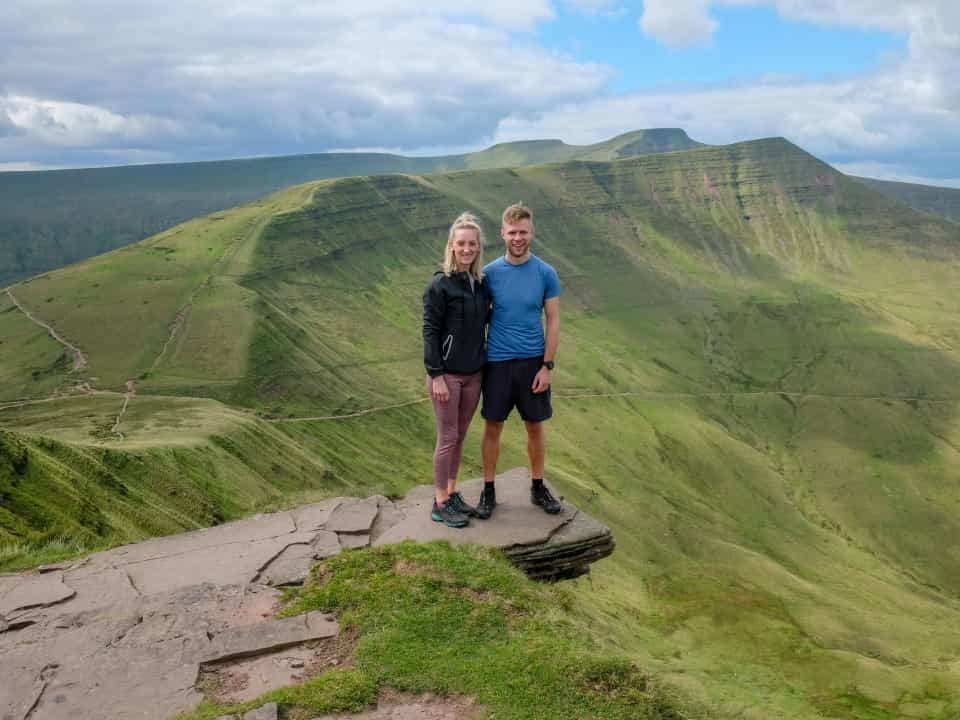 Two people stood at the top of a mountain with a view of pen y fan
