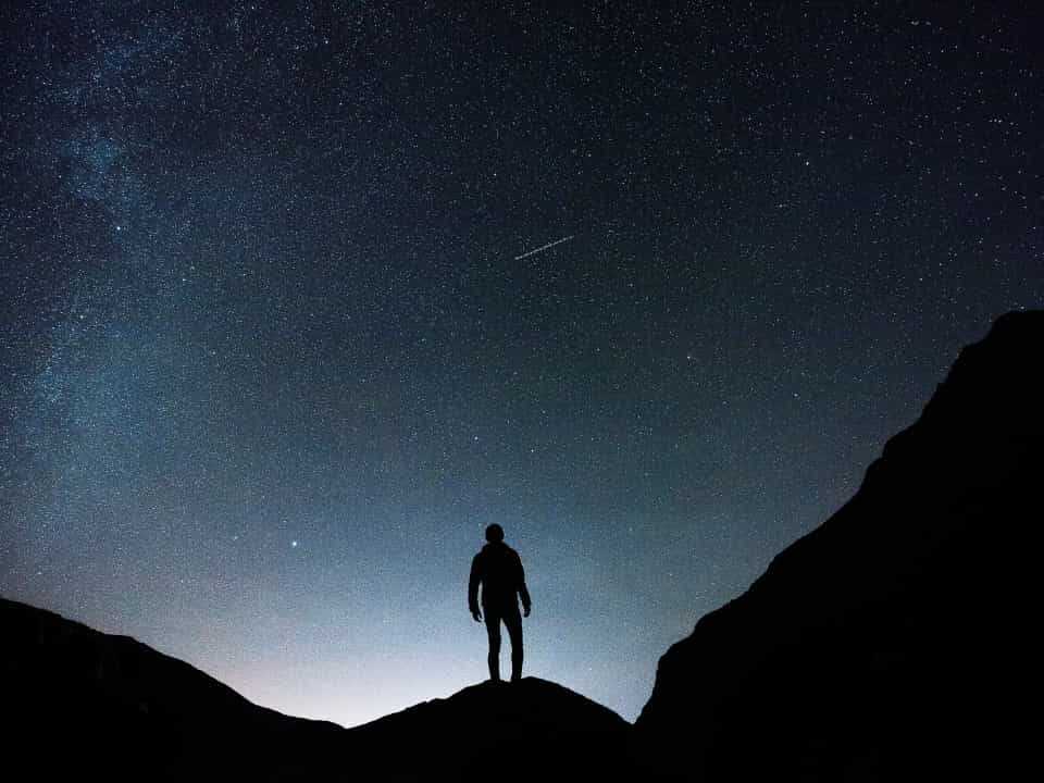 Silhouette of man on hill on starry night