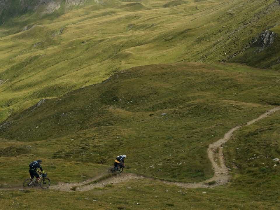 2 people riding mountain bikes down a dirt path